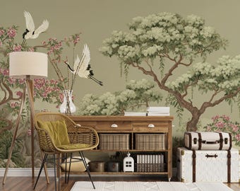 Puede incluir: Escena de una habitación con una consola de madera, una silla de ratán y una lámpara de pie. El telón de fondo es un mural que representa un jardín japonés con árboles, flores y grullas. La consola tiene cestas tejidas y cajones.