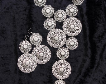Conjunto de joyas llamativas, collar babero de filigrana plateada y pendientes largos para los hombros.