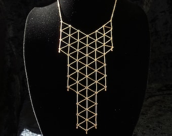 Collar babero minimalista dorado con diseño geométrico
