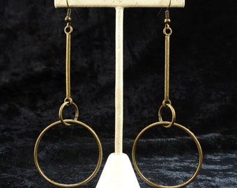 Pendientes minimalistas llamativos, ligeros y geométricos en tono bronce.