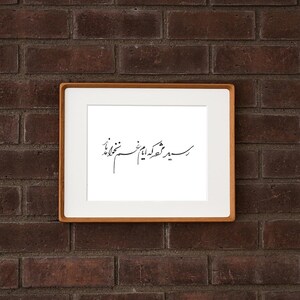 Pu&ograve; includere: Una stampa incorniciata con un passe-partout bianco e una cornice in legno marrone chiaro. La stampa presenta un'elegante calligrafia nera su sfondo bianco. L'opera incorniciata &egrave; montata su un muro di mattoni rosso scuro.