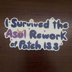 May include: A white sticker with the text "I Survived the Asol Rework of Patch 13.3" in a dark blue, stylized font. The sticker has a purple and gold graphic of a planet and stars.
