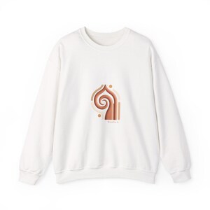 Könnte beinhalten: Weißes Sweatshirt mit einem braunen und beigefarbenen Grafikdesign. Die Grafik zeigt eine Spiralform mit den Worten "Breathe In" darunter. Das Sweatshirt hat einen Rundhalsausschnitt und lange Ärmel.