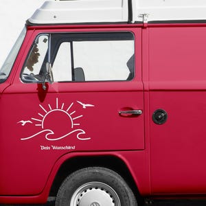 May include: A red vintage van with a white roof. A white graphic of a sun, waves, and birds is on the side. The text "Dein Wunschtext" is below the graphic. The van has a spare tyre on the front.