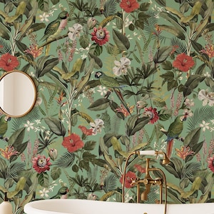 May include: A bathroom scene featuring a white clawfoot bathtub with gold accents, a beige rug, and a small wooden stool. The wallpaper has a tropical design with parrots, flowers, and lush green foliage. A round mirror and a lamp are also visible.