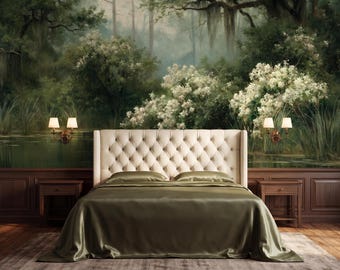 May include: A tufted beige upholstered headboard with a matching beige bed frame and olive green satin bedding. The bed is positioned against a wall mural depicting a lush forest landscape with white flowering bushes and a calm pond.