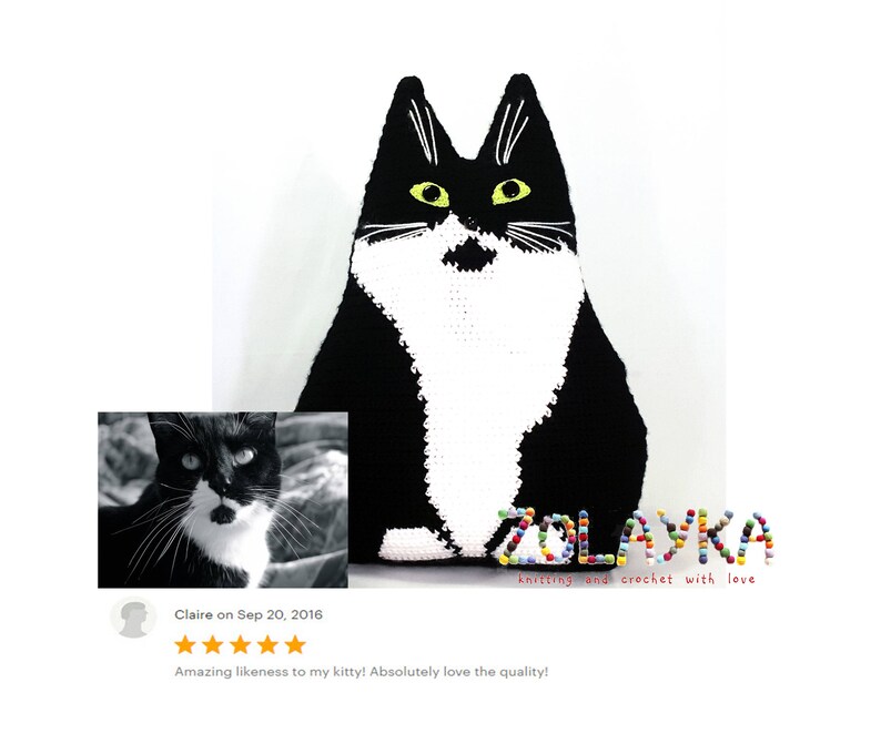K&ouml;nnte beinhalten: Schwarz-wei&szlig;es geh&auml;keltes Katzenkissen mit gelben Augen. Das Kissen liegt auf einer wei&szlig;en Oberfl&auml;che. Der Text "ZOLAYKA knitting and crochet with love" befindet sich unter dem Kissen.