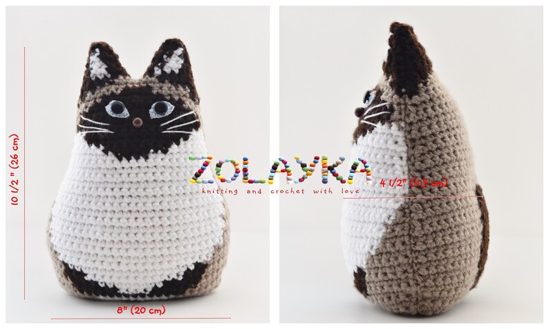 A crocheted cat toy in white and brown. The cat is sitting up and looking to the right. The cat is 10 1/2 inches tall and 8 inches wide. The cat is made by ZOLAYKA knitting and crochet with love.