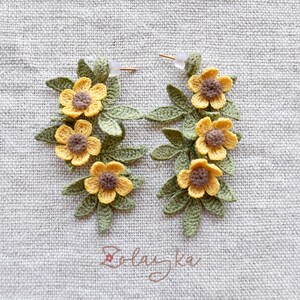 Artisan crochet earrings in buttercup flower design, photographed to show texture and handmade details