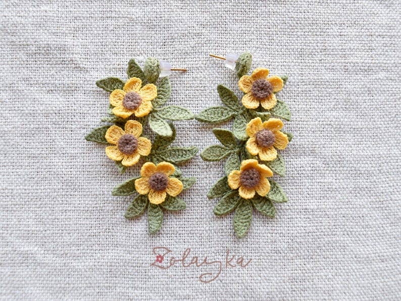 Artisan crochet earrings in buttercup flower design, photographed to show texture and handmade details