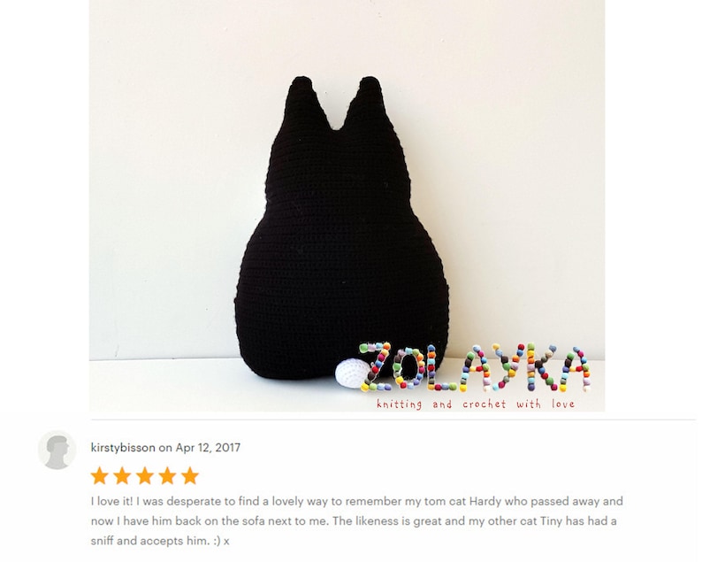 K&ouml;nnte beinhalten: Ein schwarzes geh&auml;keltes Katzenkissen mit dem Namen "ZOLAYKA", der in bunten Perlen geschrieben ist. Der Text "knitting and crochet with love" befindet sich unter dem Namen.