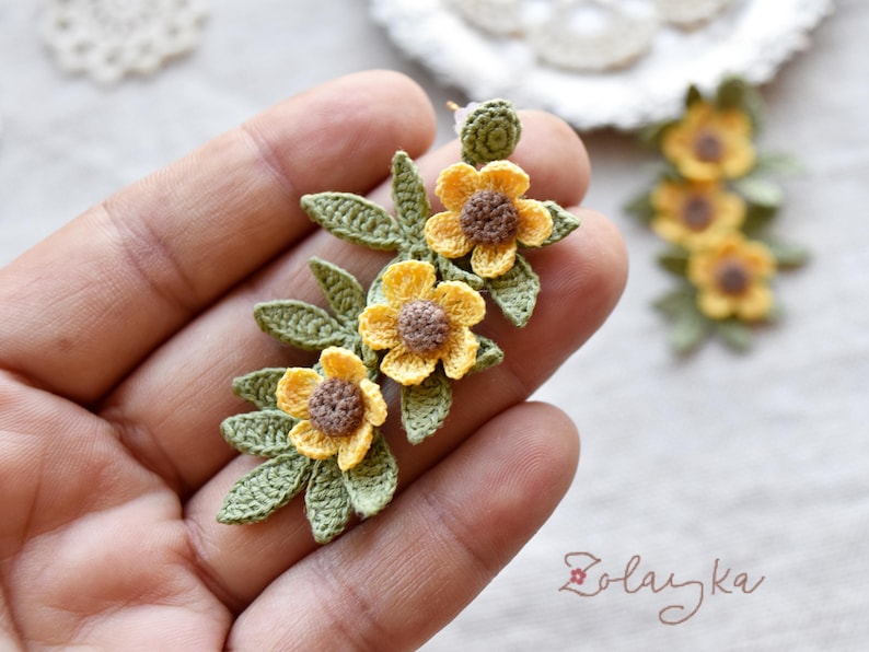 Handmade micro crochet buttercup earrings with yellow flowers and green leaves on 18K gold studs, 5 cm long.