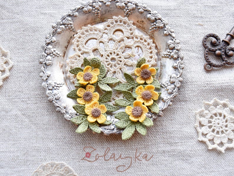 Artisan crochet earrings in buttercup flower design, photographed to show texture and handmade details.