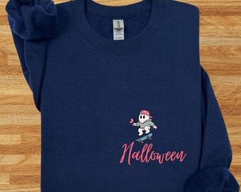 May include: Navy blue sweatshirt with a Halloween-themed design. The design features a cartoon ghost wearing a pink cap and riding a skateboard, with the word "Halloween" in pink script below.