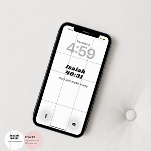 May include: A black smartphone displays a white lock screen with the text "Isaiah 40:31 God will make a way." The time is 4:59 on Thursday, February 12. Two circular stickers with text are in the lower left.