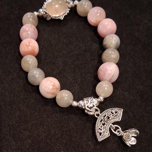 May include: A set of three ceramic mugs with a speckled, matte finish. The mugs are in shades of cream, light gray, and dark gray. Each mug has a simple, minimalist design and a rounded handle.