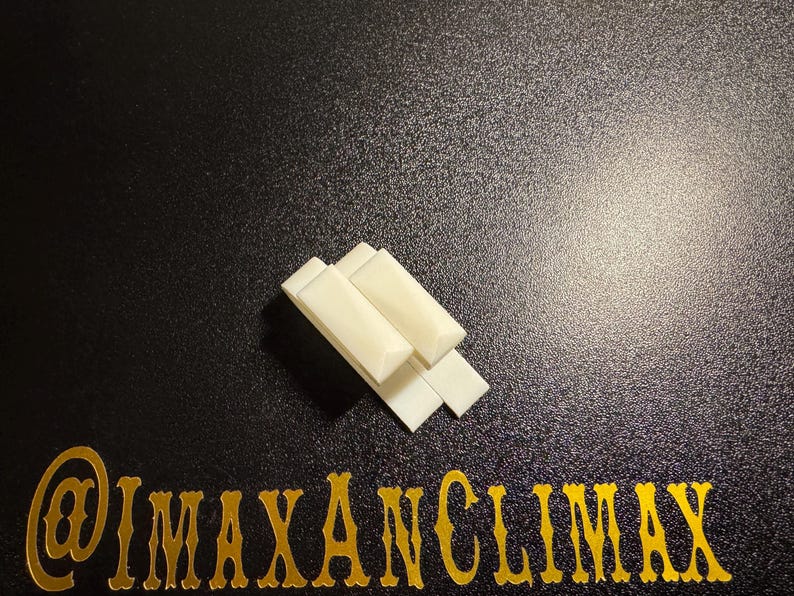 May include: Four off-white rectangular objects are stacked on a black surface. The objects are arranged in a slightly overlapping pattern. The text "@IMAXANCLIMAX" is displayed in gold lettering at the bottom of the image.
