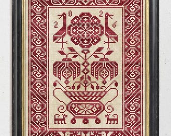 May include: A framed cross-stitch embroidery featuring a deep red geometric pattern on a light beige fabric. The design displays a central floral motif in a decorative urn, flanked by two birds and the year 2016, all enclosed in a border.
