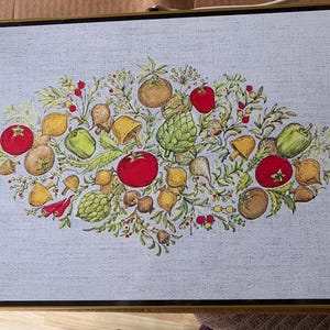 May include: A framed artwork featuring a colorful illustration of various vegetables. The arrangement includes red tomatoes, green peppers, artichokes, and mushrooms, with a light gray background. The artwork is framed in a gold-colored frame.
