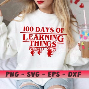 May include: White sweatshirt with the text "100 Days of Learning Things" in red. Below the text are three red silhouettes of figures on bicycles. The bottom of the image has the text "PNG - SVG - EPS - DXF" in white on a red background.