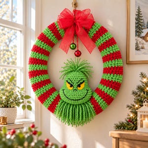 May include: A circular crochet wreath featuring alternating horizontal stripes of bright red and lime green yarn. A large red organza bow sits at the top with two small hanging jingle bells. A green crocheted character face is centered inside.