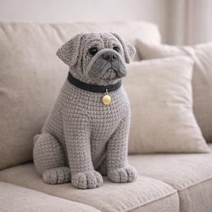 Peut inclure: Figurine de bouledogue grise au crochet, avec un collier noir et une étiquette dorée. Le chien est assis sur un canapé beige. Le chien fait à la main a un visage détaillé et est un objet décoratif.