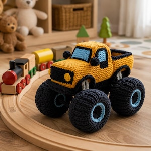 Könnte beinhalten: Ein gehäkeltes Monstertruck-Spielzeug mit einer leuchtend gelben Karosserie, schwarzen Kotflügeln und großen schwarzen Reifen mit hellblauen kreisförmigen Akzenten. Der Truck hat eine hellblaue Windschutzscheibe und Seitenfenster sowie kleine schwarze Scheinwerfer.