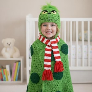 May include: A green crocheted Grinch-themed costume set. The set includes a hat with a Grinch face, a green cape with green circles, and a red and white striped scarf with red tassels. The costume is designed for children.