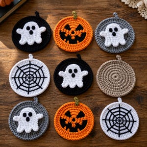 May include: A set of nine circular crochet coasters featuring Halloween designs. The collection includes white ghosts on black and gray backgrounds, orange jack-o'-lanterns with black faces, black spiderwebs on white, and a solid tan coaster.