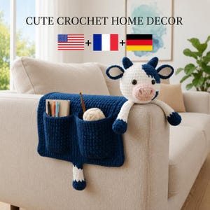 May include: A navy blue crochet sofa organizer with two pockets and a crochet cow attached. The cow is white with navy blue spots and accents. The text "CUTE CROCHET HOME DECOR" is at the top of the image.