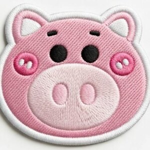 Puede incluir: Parche bordado con la cara de un cerdo rosa con ojos negros, mejillas rosas y un hocico rosa claro. El parche tiene un borde blanco y est&aacute; dise&ntilde;ado con un estilo de dibujos animados. Las orejas del cerdo tienen la punta blanca.