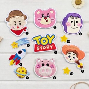 Puede incluir: Una colecci&oacute;n de parches bordados con personajes y elementos de la pel&iacute;cula "Toy Story". Incluye parches de Woody, Buzz Lightyear, Jessie, Lotso, Hamm y el logotipo de "Toy Story", junto con un cohete, un planeta y estrellas.