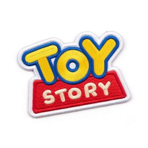 Puede incluir: Parche bordado con el logotipo de "Toy Story". El parche tiene un borde blanco, con las palabras "TOY" en amarillo y azul, y "STORY" en blanco sobre un fondo rojo. El parche est&aacute; dise&ntilde;ado para plancharse.
