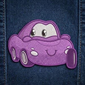 Puede incluir: Parche de coche bordado p&uacute;rpura con una cara sonriente y ojos grandes y expresivos. El parche est&aacute; sobre un fondo de mezclilla azul. El coche tiene detalles blancos en las ruedas y la cara.