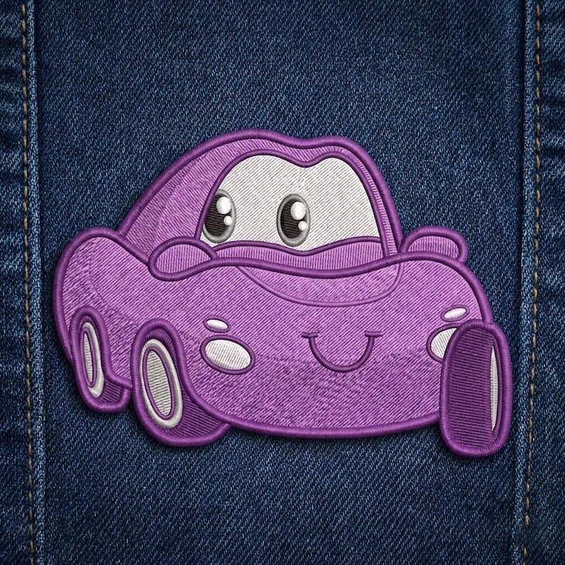 Puede incluir: Parche de coche bordado p&uacute;rpura con una cara sonriente y ojos grandes y expresivos. El parche est&aacute; sobre un fondo de mezclilla azul. El coche tiene detalles blancos en las ruedas y la cara.