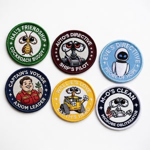 May include: A collection of six embroidered patches featuring characters and phrases from the animated film "WALL-E." The patches are round with various colors, including green, maroon, blue, and yellow. Each patch has a unique design and text.