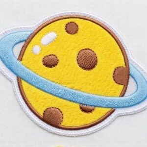 Puede incluir: Una taza de cer&aacute;mica blanca con asa negra y el texto "But First, Coffee" en negrita negra. La taza se encuentra sobre un fondo borroso, sugiriendo un ambiente acogedor.