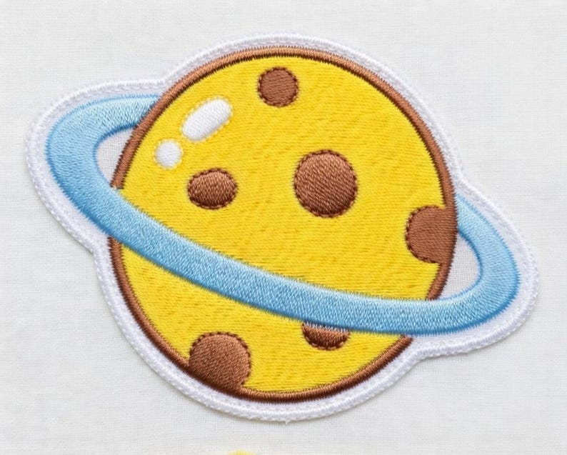 Puede incluir: Una taza de cer&aacute;mica blanca con asa negra y el texto "But First, Coffee" en negrita negra. La taza se encuentra sobre un fondo borroso, sugiriendo un ambiente acogedor.