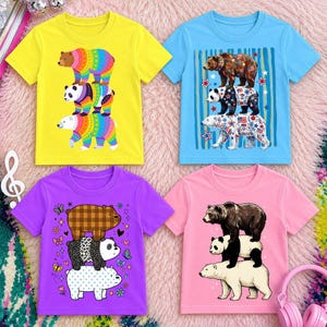 May include: Four short-sleeve t-shirts in yellow, blue, purple, and pink, each featuring a graphic print of three stacked bears. The designs include rainbow patterns, patriotic stars and stripes, plaid and leopard prints, and realistic fur textures.