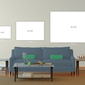 K&ouml;nnte beinhalten: Wohnzimmerszene mit blauem Sofa, gr&uuml;nen Kissen und Glastischen. Drei leere Leinw&auml;nde an der Wand, mit den Ma&szlig;en 40,6 x 61 cm, 61 x 91,4 cm und 101,6 x 152,4 cm. Ein Teppich bedeckt den Boden.