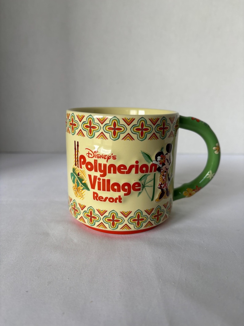 May include: A ceramic mug featuring the text "Disney's Polynesian Village Resort" in red and yellow. The mug has a green handle and a decorative pattern in red, yellow, and green. Mickey Mouse and Minnie Mouse are depicted on the side.