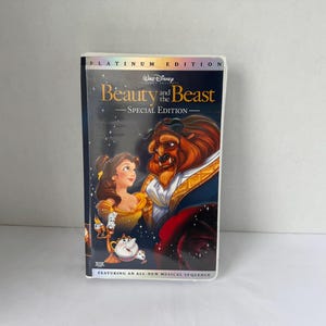 May include: A VHS tape of Disney's "Beauty and the Beast: Special Edition." The cover features Belle and the Beast, with the title in gold lettering. The tape is in a white case with the text "Platinum Edition" at the top.