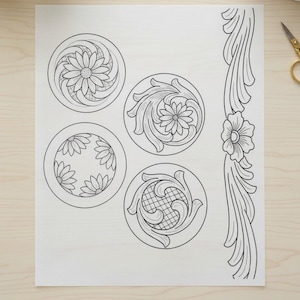 May include: A sheet of paper with four circular floral designs and a vertical floral border, all in black line art. The designs feature daisies and swirling patterns, suitable for leathercraft or similar projects.