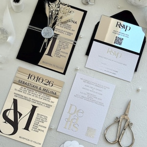 May include: Elegant wedding invitation suite featuring black and gold cards with event details. Includes an RSVP card, details card, and a card with the couple's names and date. Embellished with pearls, dried flowers, and a silver crown.