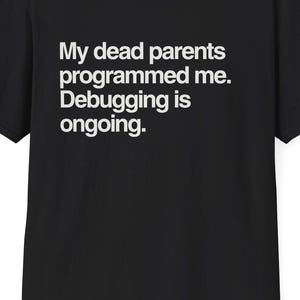 Puede incluir: Camiseta negra con texto blanco: "My dead parents programmed me. Debugging is ongoing." La camiseta de cuello redondo es de algodón. El sitio web DeadParents.com está impreso en la parte superior. Una prenda informal para el día a día.