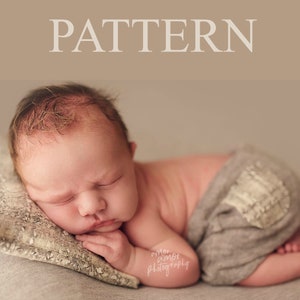Peut inclure: Un nouveau-né dort sur un oreiller à motifs gris, vêtu d'une couche à motifs gris et blancs. Le bébé a le teint clair et a une expression neutre.