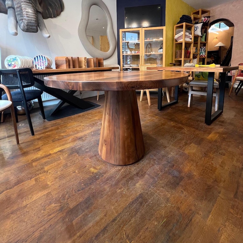 Puede incluir: Una mesa de comedor redonda de madera grande con una base de pedestal. La mesa est&aacute; hecha de madera de color marr&oacute;n oscuro y tiene un patr&oacute;n de vetas natural. La mesa est&aacute; en una habitaci&oacute;n con otros muebles y decoraci&oacute;n.