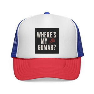 May include: A trucker hat with a white front panel, a red bill, and a blue mesh back. The hat features the text "WHERE'S MY GUMAR?" in white, with a red rose graphic on a black square.