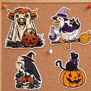 May include: Four embroidered patches featuring Halloween themes: a highland cow in a ghost costume with a pumpkin bucket, a goose in a witch hat riding a broom with a black cat and potion, a crow with a coffee mug on a skull, and a black cat on a pumpkin.