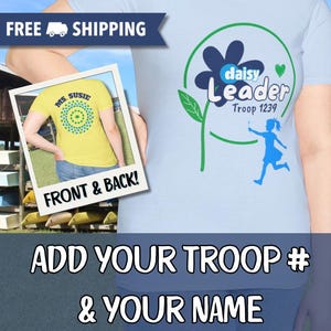 May include: Light blue t-shirt with a daisy flower design and the words "daisy Leader Troop 1239". The shirt also features a graphic of a girl and the text "ADD YOUR TROOP # & YOUR NAME". A second image shows the back of a yellow shirt.